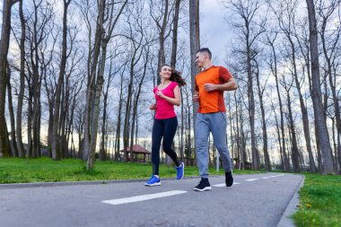 Parkta koşan atletik ve çekici genç çift