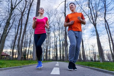 Parkta koşan atletik ve çekici genç çift