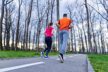 Parkta koşan atletik ve çekici genç çift