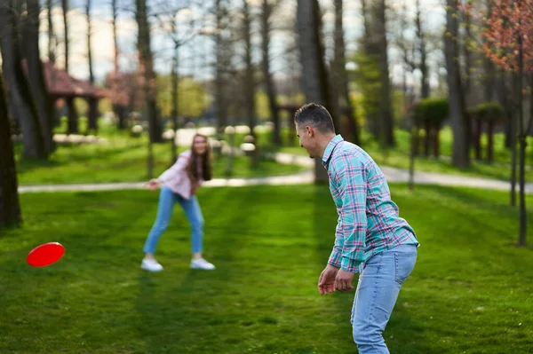 Sıradan Giyimli Genç Çift Parkta Freesbie Oynuyor — Stok fotoğraf