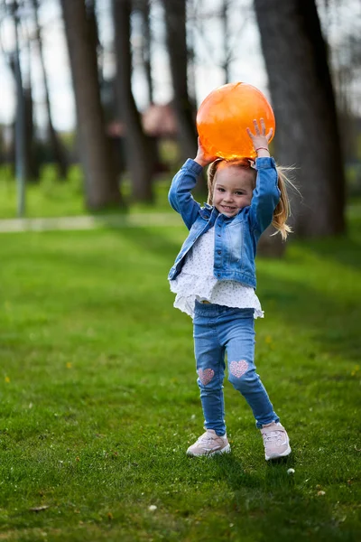 Menina Brincando Com Uma Bola Laranja Grama Parque — Fotografia de Stock