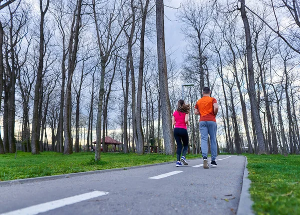 Atletica Attraente Giovane Coppia Che Corre Nel Parco — Foto Stock