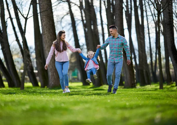 春に公園で素晴らしい品質の時間を持っている母親 父と小さな娘の幸せな若い家族 — ストック写真
