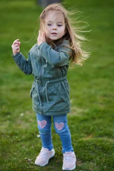 公園の牧草地で幸せな小さなブロンドの女の子 — ストック写真