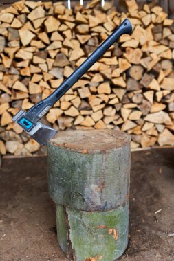Bir odun yığını tarafından kütüğün içinde ağır bir balta.