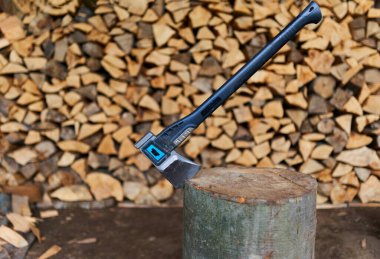 Bir odun yığını tarafından kütüğün içinde ağır bir balta.