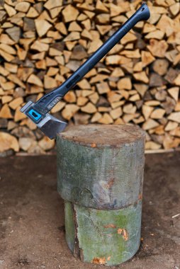 Bir odun yığını tarafından kütüğün içinde ağır bir balta.