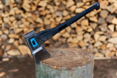 Bir odun yığını tarafından kütüğün içinde ağır bir balta.