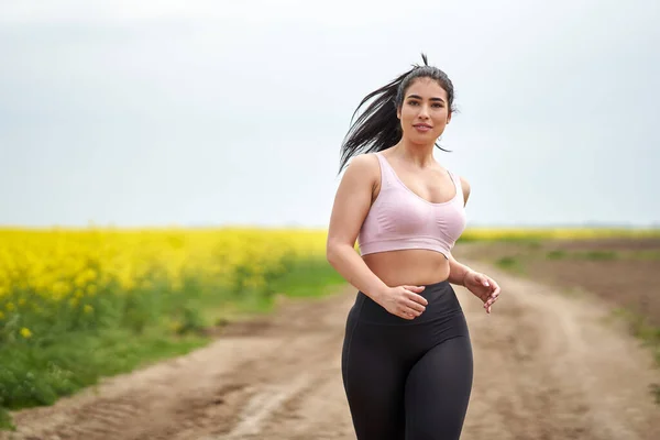 Velikost Krásné Latinské Ženy Jogging Polní Cestě Canola Pole — Stock fotografie