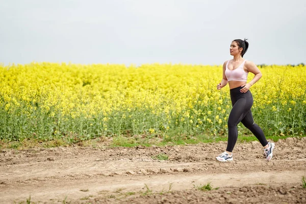 Velikost Krásné Latinské Ženy Jogging Polní Cestě Canola Pole — Stock fotografie