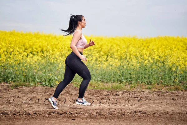 Size Bella Donna Latina Jogging Una Strada Sterrata Campo Colza — Foto Stock