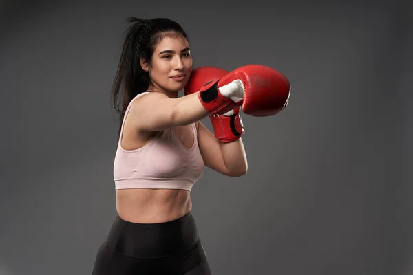 プラスサイズ若いですヒスパニック女性ボクサーで赤ボクシング手袋トレーニングでグレー背景 — ストック写真