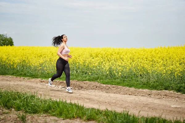 Velikost Krásné Latinské Ženy Jogging Polní Cestě Canola Pole Royalty Free Stock Obrázky