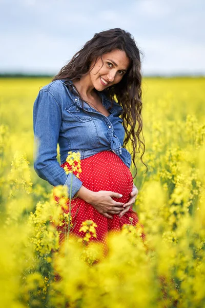 カノーラ畑で幸せな若い妊婦 — ストック写真