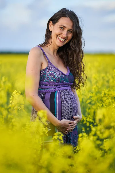 カノーラ畑で幸せな若い妊婦 — ストック写真