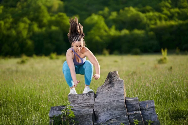 身材加上穿着运动服的年轻女子在森林里进行体重增加的健身锻炼 — 图库照片