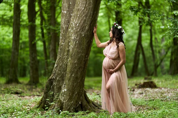 夏天在落叶森林里一个年轻貌美的惊慌失措的孕妇的画像 — 图库照片