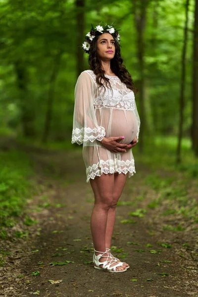 夏天在落叶森林里一个年轻貌美的惊慌失措的孕妇的画像 — 图库照片
