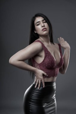 İspanyol artı boyut, gri arka planda güzel bir genç kadın.