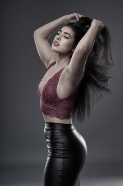 İspanyol artı boyut, gri arka planda güzel bir genç kadın.