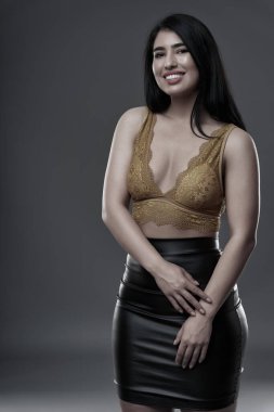 İspanyol artı boyut, gri arka planda güzel bir genç kadın.