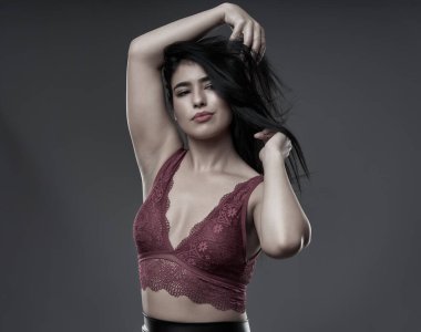 İspanyol artı boyut, gri arka planda güzel bir genç kadın.