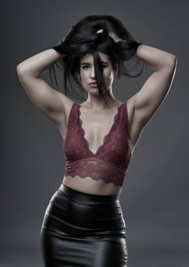 İspanyol artı boyut, gri arka planda güzel bir genç kadın.