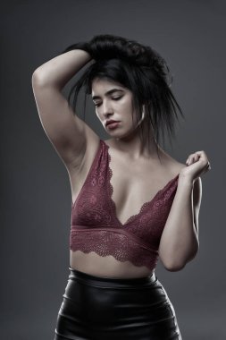 İspanyol artı boyut, gri arka planda güzel bir genç kadın.