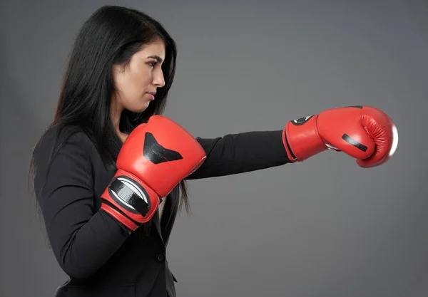 戦闘精神を持つ若いヒスパニック系の実業家 グレーの背景に赤いボクシングの手袋で — ストック写真