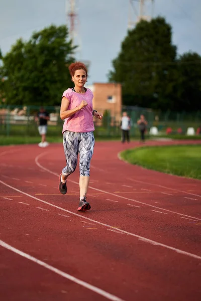 Donna Che Corre Una Pista Città Tramonto — Foto Stock