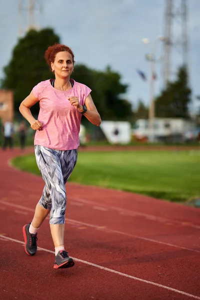 Donna Che Corre Una Pista Città Tramonto — Foto Stock