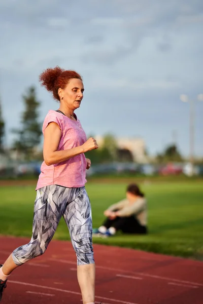 Donna Che Corre Una Pista Città Tramonto — Foto Stock