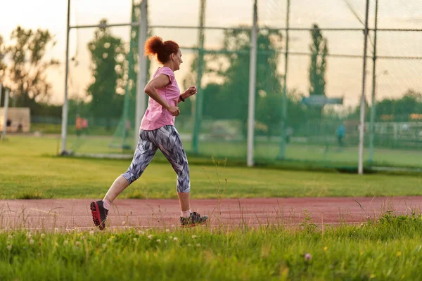 Donna Che Corre Una Pista Città Tramonto — Foto Stock