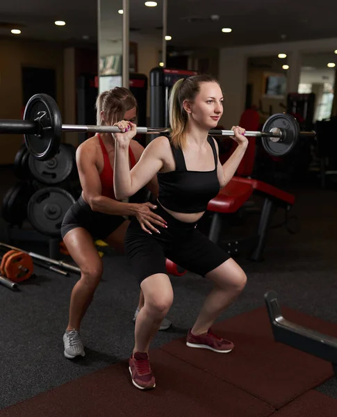 Kadın Kişisel Antrenör Spor Salonunda Barbelll Çömelmesine Yardım Ediyor — Stok fotoğraf