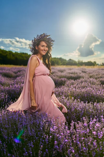 美丽的年轻孕妇在盛开的薰衣草地里 — 图库照片