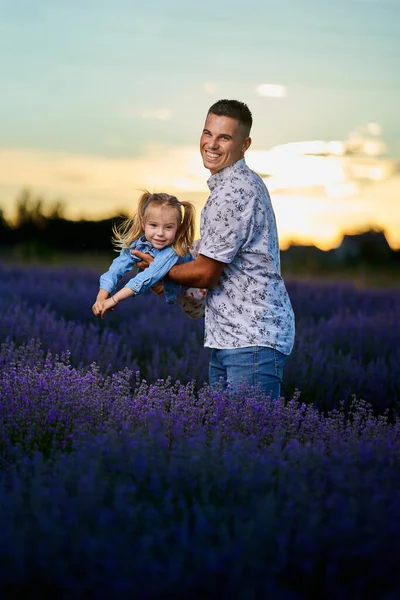 年轻的父亲和蹒跚学步的女儿在盛开的薰衣草地里玩得很开心 — 图库照片