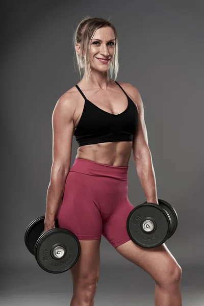 Apto Mulher Fisiculturista Fazendo Exercícios Fitness Fundo Cinza Tiro Estúdio — Fotografia de Stock