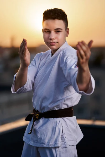Молодой Юноша Каратист Белом Кимоно Тренируется Крыше Закате — стоковое фото