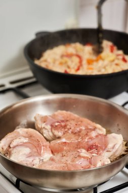 Tavuk göğsü fırındaki paslanmaz çelik tavada kızarıyor.