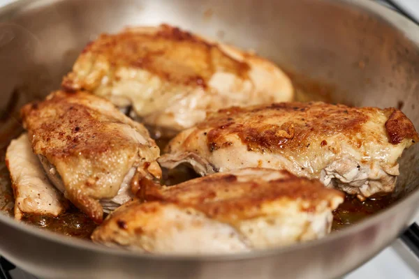 鸡胸肉在炉灶上的不锈钢锅里翻滚 — 图库照片