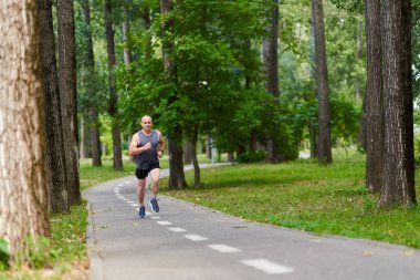 Atletik adam uzun mesafe koşucu antrenmanı yapıyor.
