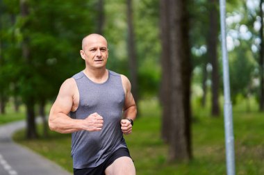 Atletik adam uzun mesafe koşucu antrenmanı yapıyor.