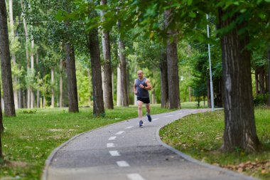 Atletik adam uzun mesafe koşucu antrenmanı yapıyor.