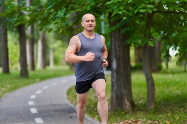Atletik adam uzun mesafe koşucu antrenmanı yapıyor.