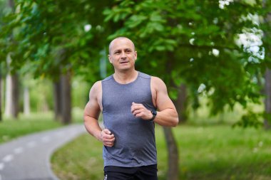 Atletik adam uzun mesafe koşucu antrenmanı yapıyor.