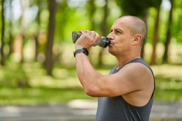 跑步者在公园里锻炼后喝水 — 图库照片