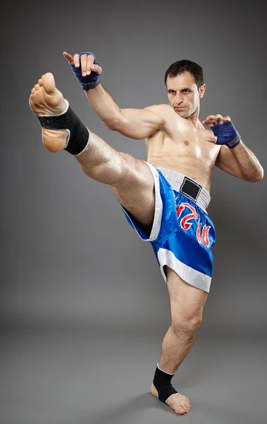 Kickbox lutador executando um chute — Fotografia de Stock