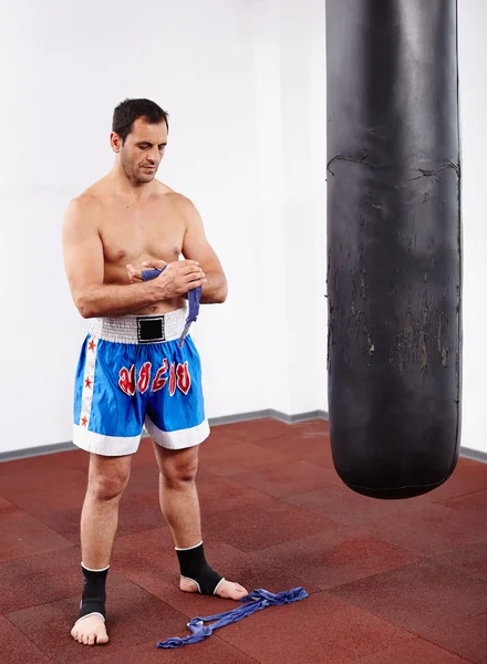 Kickboxer con saco de boxeo — Foto de Stock