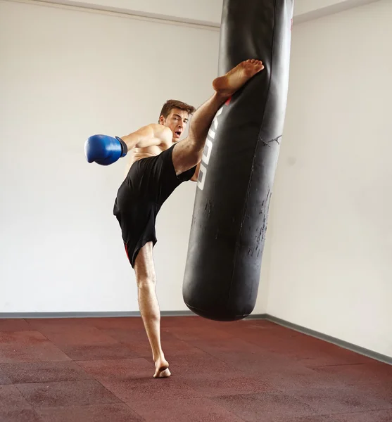 Combatiente pateando el saco de boxeo — Foto de Stock