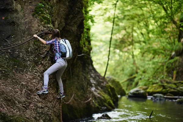 Bergsteigerin kletterte an Sicherungsseilen über Fluss — Stockfoto